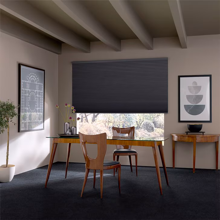 A charcoal cellular shade lowered half way across a wide dining room window under beamed ceilings