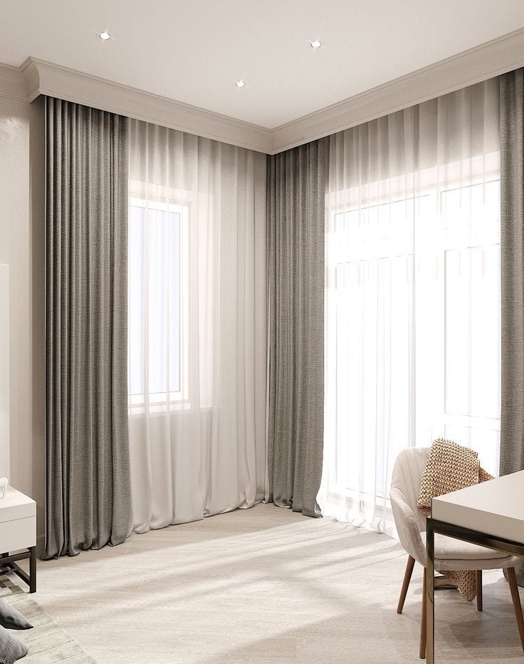 Grey curtains and white sheers on a ceiling track in a corner room
