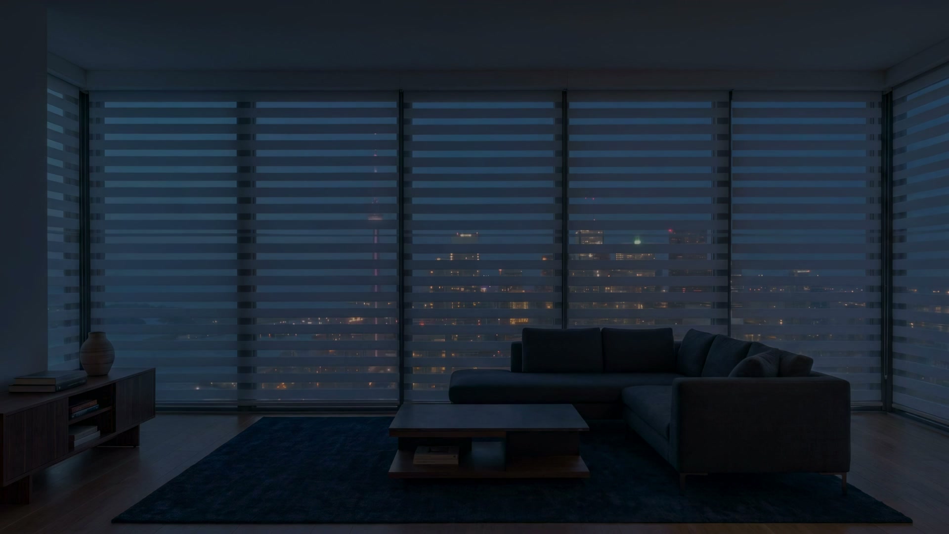Zebra shades drawn closed over the penthouse windows at night, the city glowing through the fabric